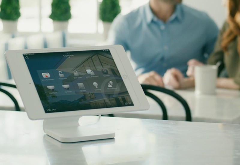 A Control4 touchpad with a smart home interface is prominently displayed on a kitchen counter. 